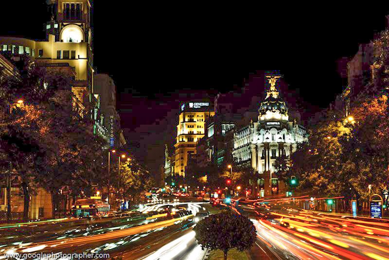 Long-exposure image of Metropolis Building in Madrid with light trails, highlighting night-time cityscape travel photography