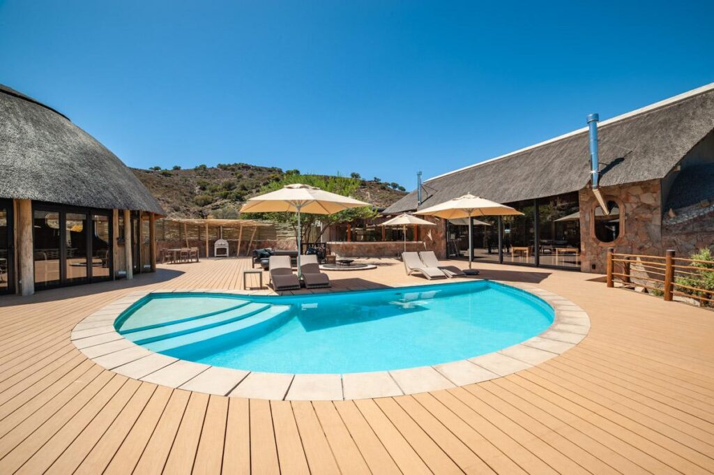 Outdoor pool at a luxury Klein Karoo lodge at golden hour, hospitality and travel photography in South Africa